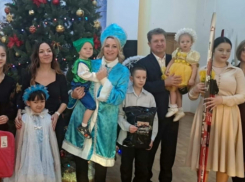 Глава Камышина Станислав Зинченко взял на руки девочку для новогоднего фото под елкой