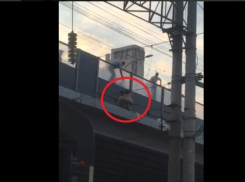 Абсолютно голый мужчина перебрался через перила железнодорожного моста в центре Волгограда и порывался прыгнуть на пути, на головы пассажирам (видео)