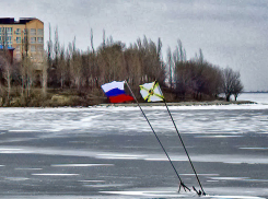 Символические флаги на льду реки у Бородинского моста в Камышине наклонились от ветра, но их снова укрепили  металлическими конструкциями