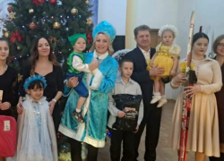 Глава Камышина Станислав Зинченко взял на руки девочку для новогоднего фото под елкой