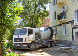 В Камышине у дома под капремонтом на улице Титова рабочие бригады выполняют отмостки