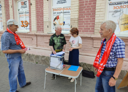 Какие бюллетени вручают прохожим активисты в красных шарфах у центрального рынка в Камышине?