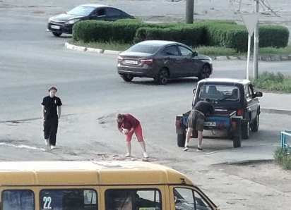 В Камышине водители авто от безысходности вынуждены останавливаться на дороге, чтобы чем-то заделать самые опасные ямы на своем пути