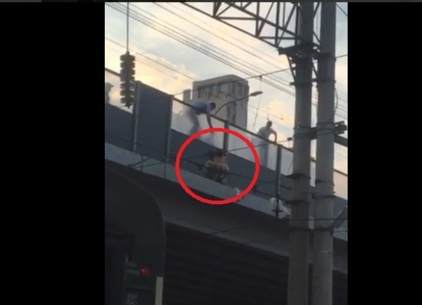 Абсолютно голый мужчина перебрался через перила железнодорожного моста в центре Волгограда и порывался прыгнуть на пути, на головы пассажирам (видео)